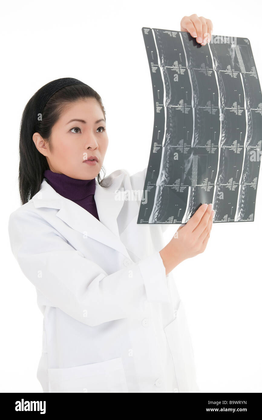 Schöne asiatische Arzt lesen ein mri auf weißem Hintergrund Stockfoto