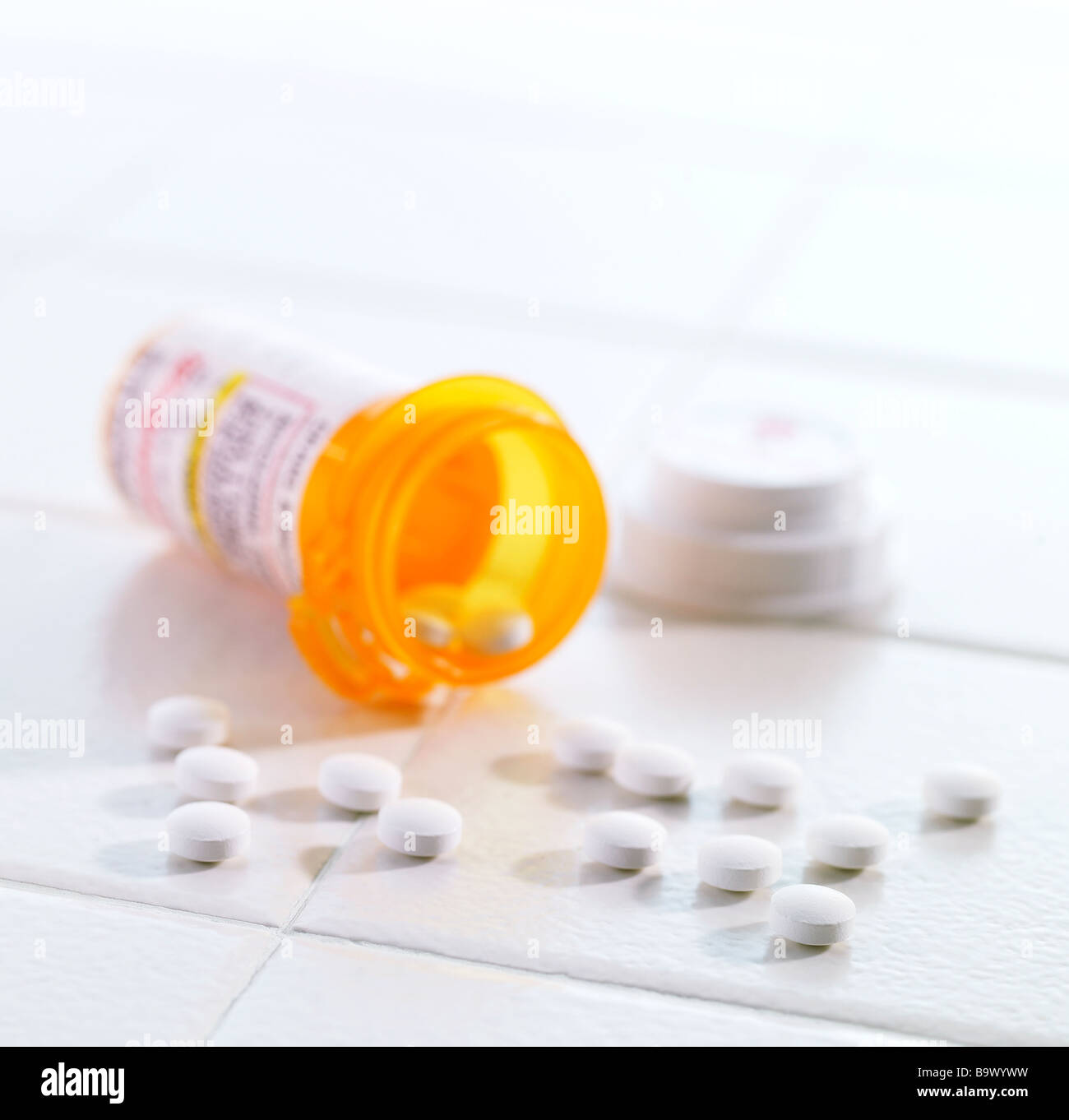 Pille-Flasche mit Pillen ergoss sich auf einer Fliese Stockfoto