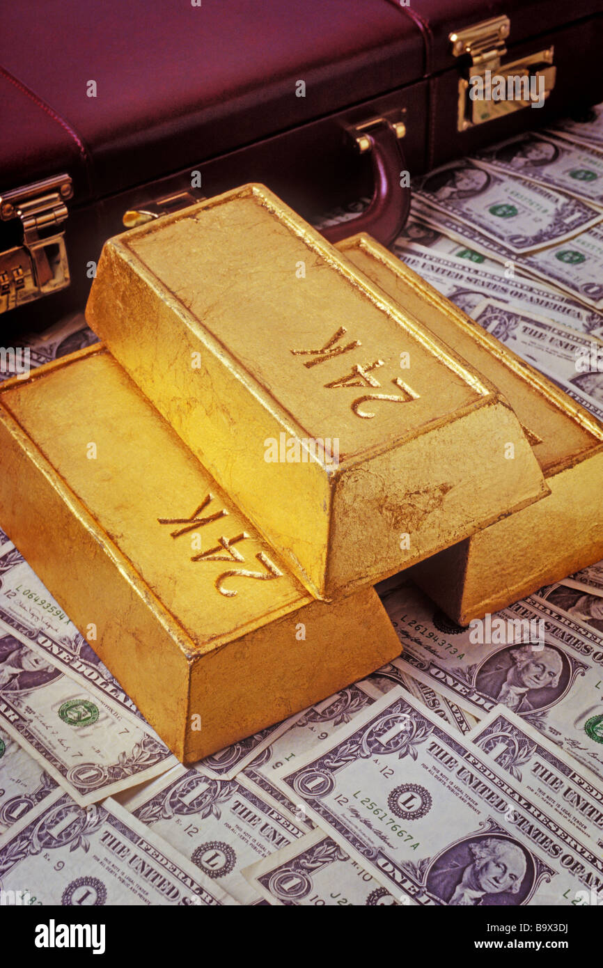 Goldbarren und Bargeld mit dem Aktenkoffer Stockfoto