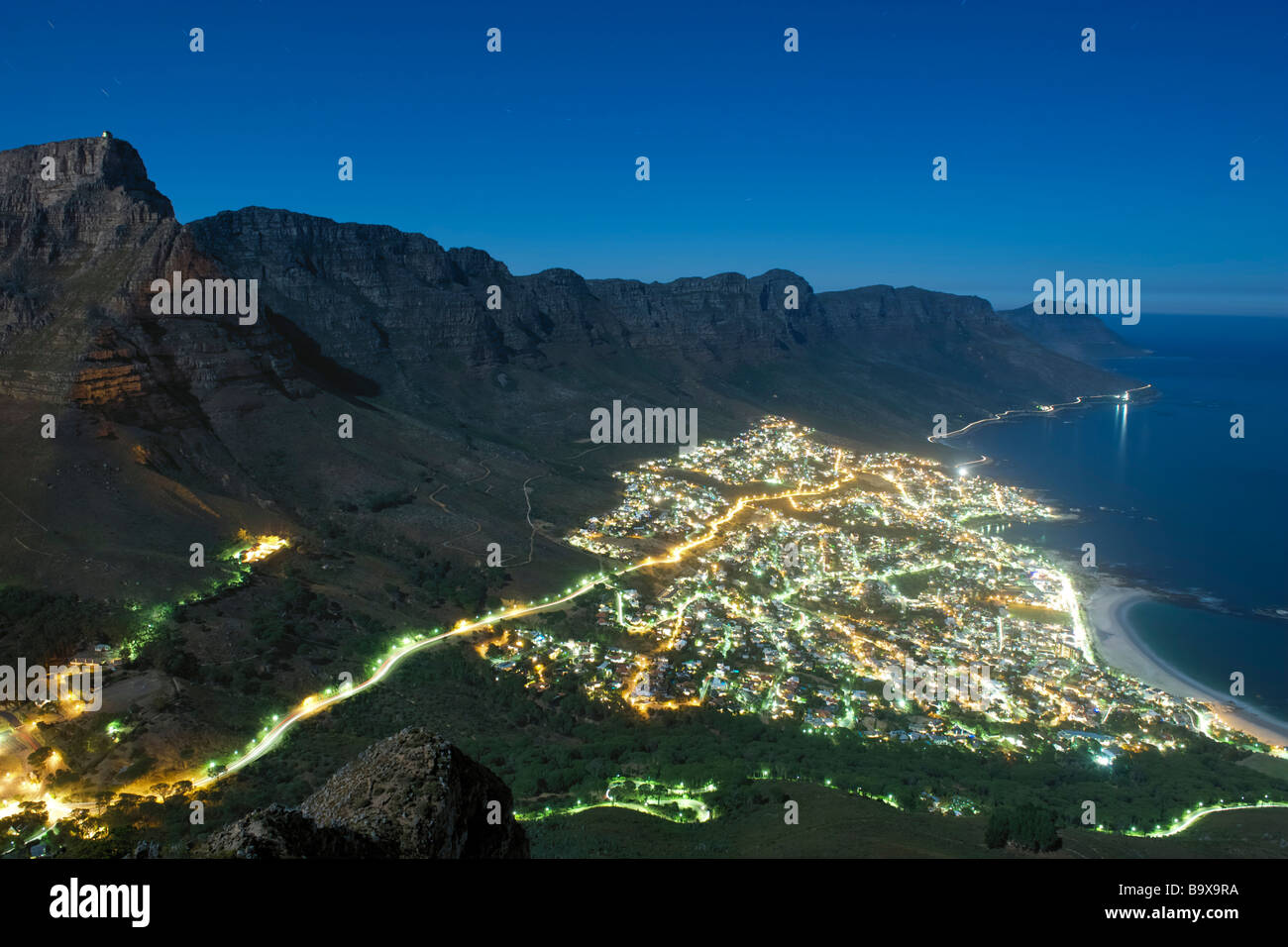 Nächtliche, Mondschein Ansicht des Vororts von Camps Bay und die zwölf Apostel Berge in Cape Town, Südafrika. Stockfoto