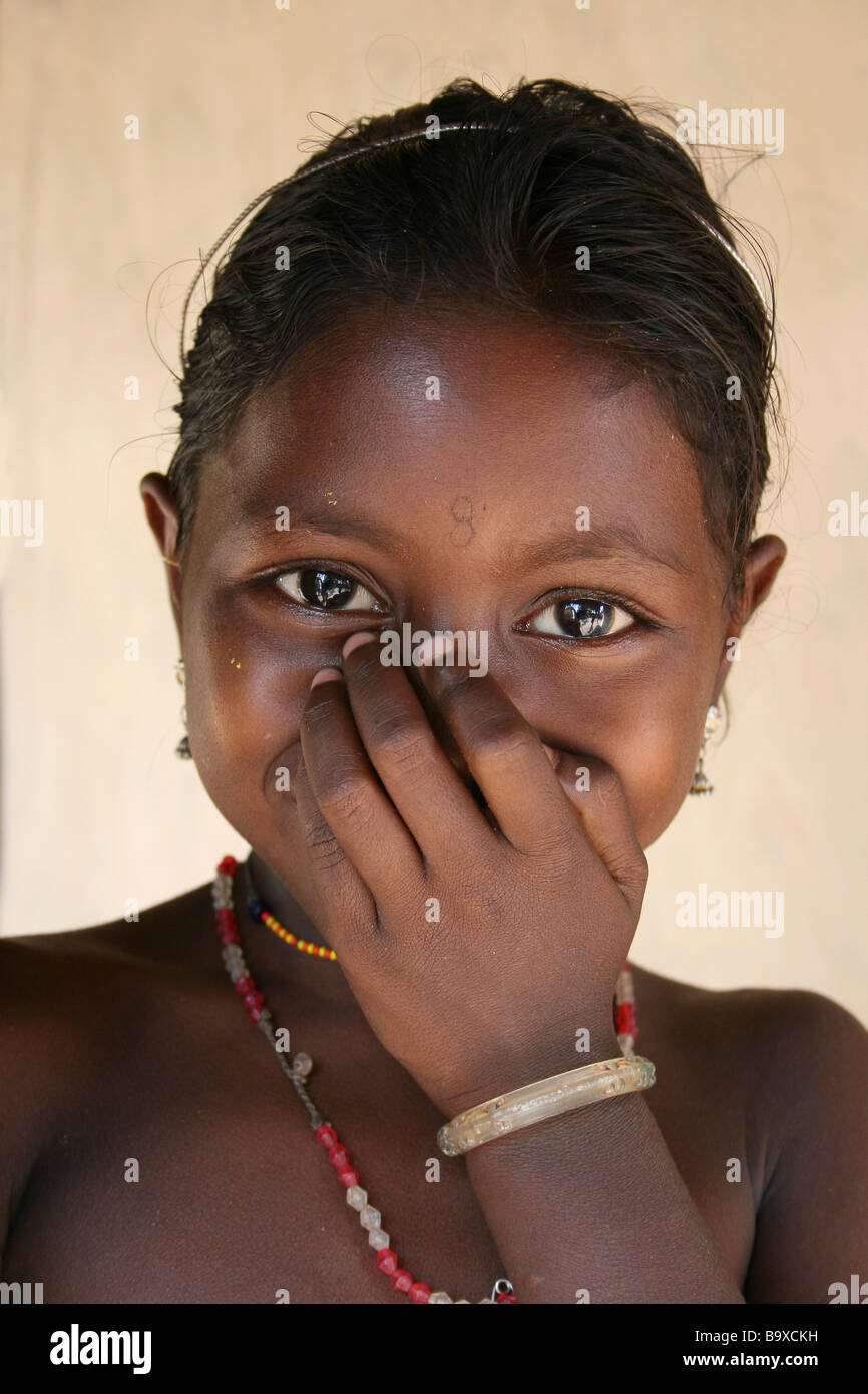 Porträt von Bright-eyed kichernde Indianerstamm Dhuruba Mädchen mit der Hand über den Mund Stockfoto