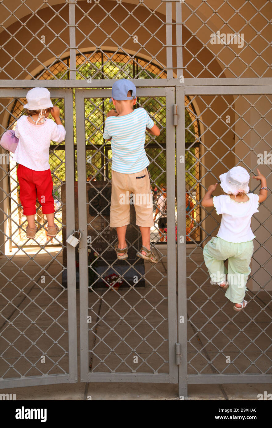 Drei Kinder hängen vom Tor grill Stockfoto