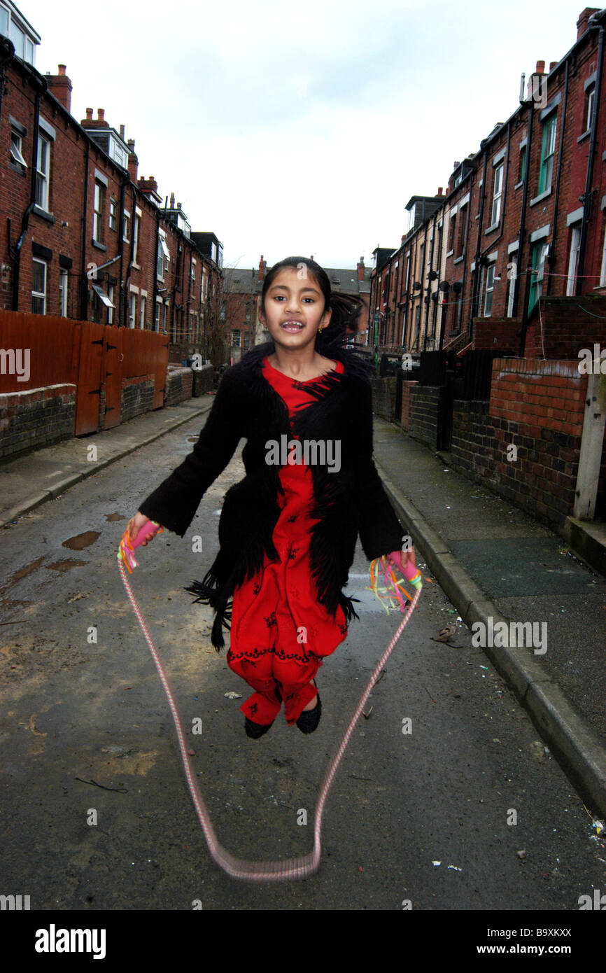 Eine Mädchen spielt sich auf den innerstädtischen Straße Beeston, Leeds Stockfoto