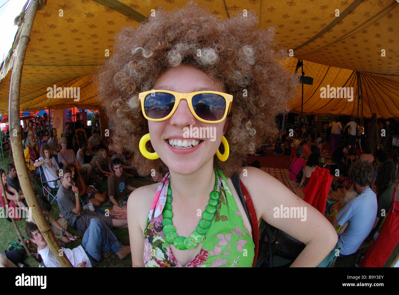 glückliches Mädchen mit großen lockiges Haar & große gelbe Sonnenbrille & Earings Big Chill Music Festival Stockfoto