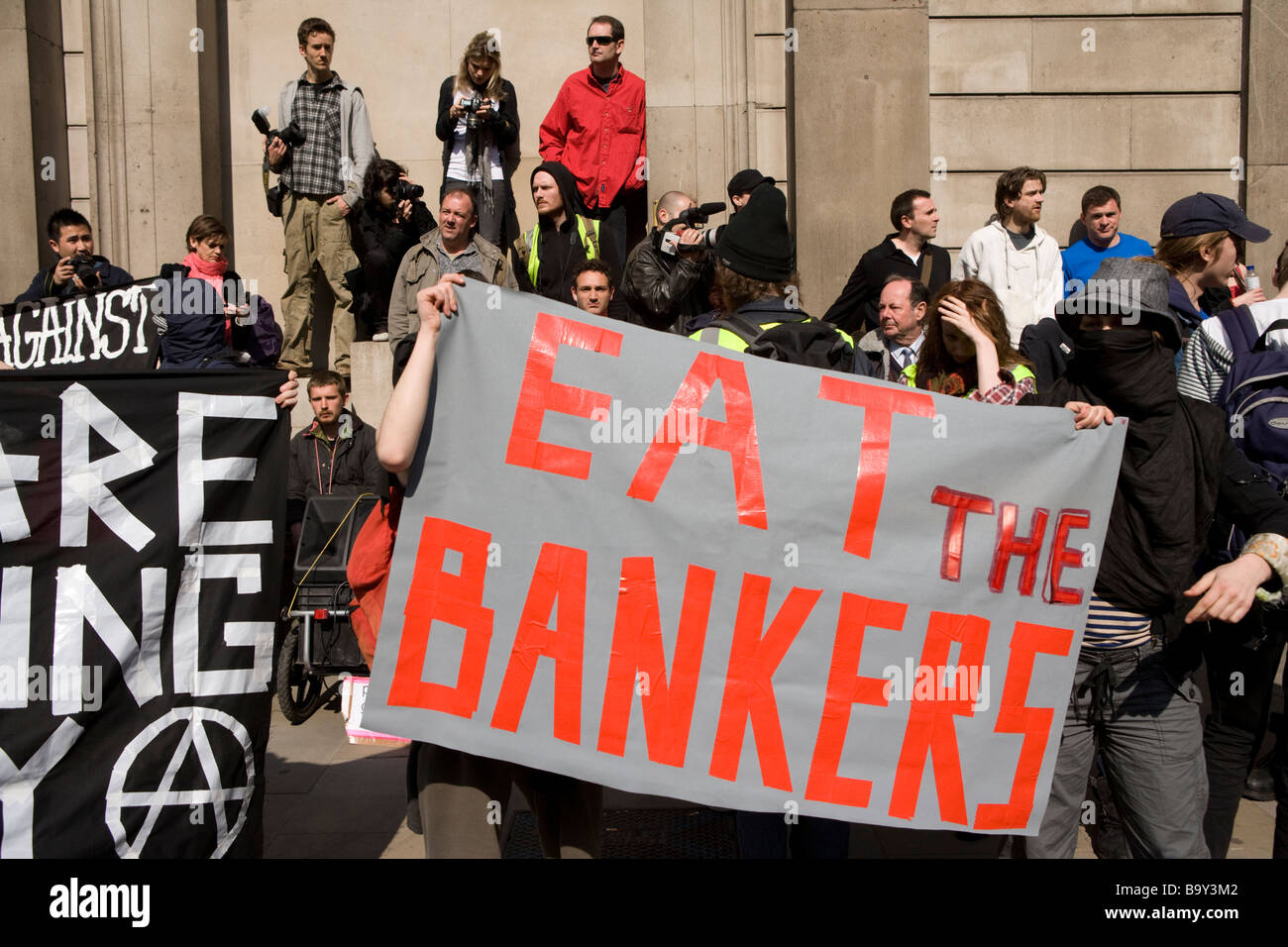 Demonstranten mit: Eat The Banker Plakat, bei der Bank of England protestieren auf dem G20-Gipfel in London. 1. April 2009 Stockfoto