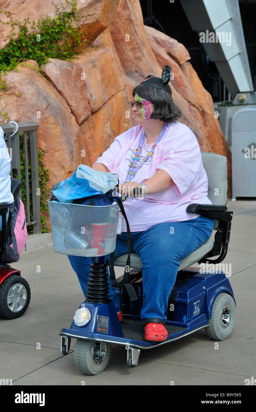 Übergewicht behinderten weiße Hündin mit Mäuseohren reitet Elektroroller an  Disney Magic Kingdom Orlando Florida Stockfotografie - Alamy