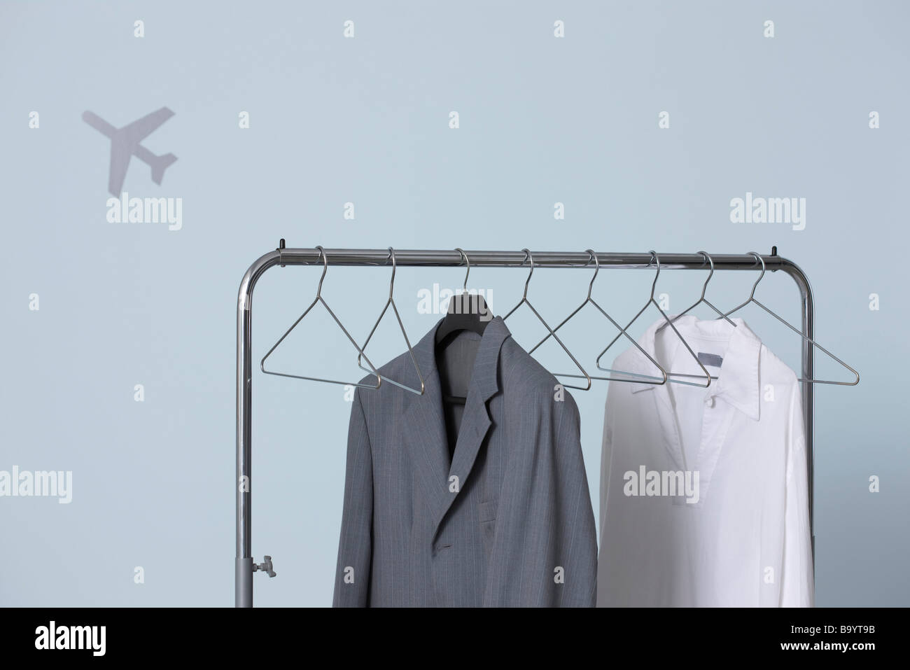 Mannes formale und legere Outfits hängen, Kleiderständer, Flugzeug-Form im Hintergrund Stockfoto