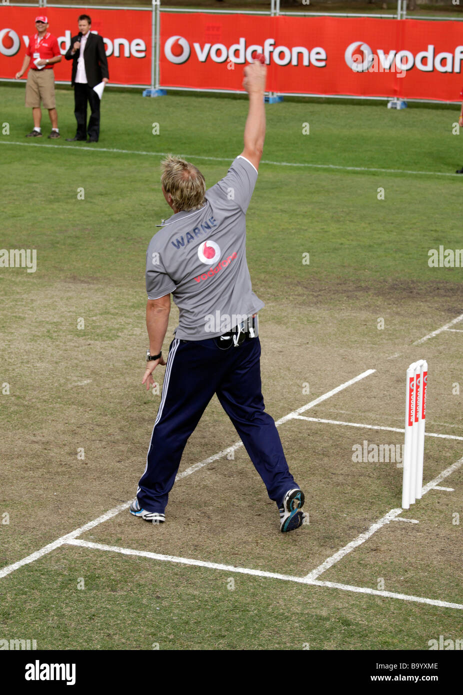 Shane Warne bowling ein Cricketball bei einem Formel 1-Fahrer Lewis Hamilton in Melbourne, 26. März 2009 Stockfoto