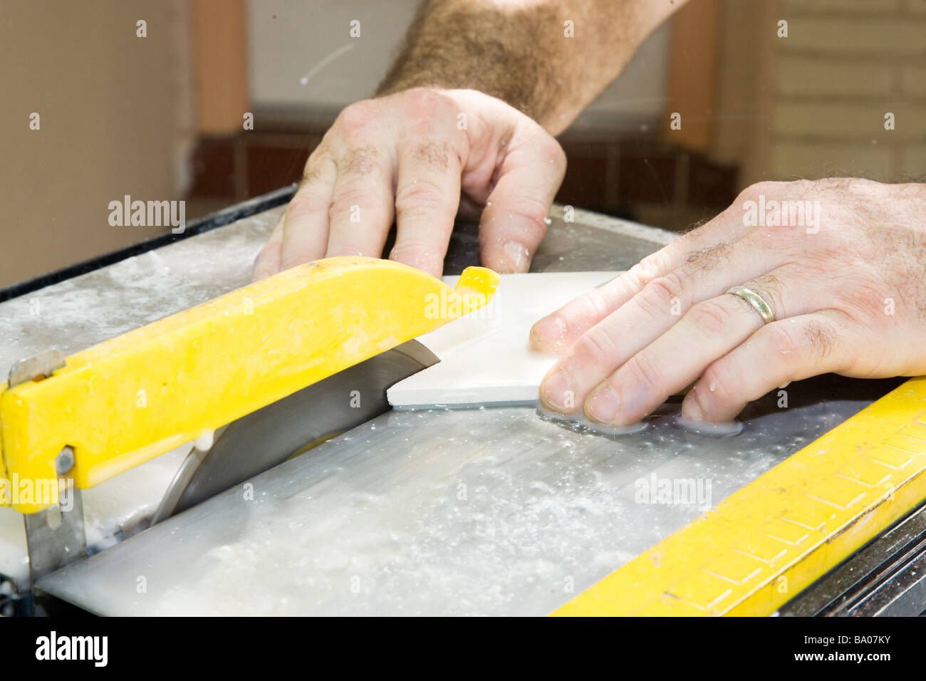 Nahaufnahme der Arbeitnehmer Hände schneiden keramische Fliesen mit einer Tischkreissäge Stockfoto