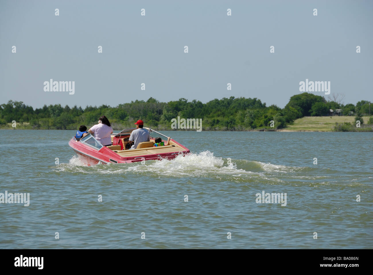 Eine vierköpfige Familie genießt einen Tag von Bootfahren auf einem Gebiet See Stockfoto