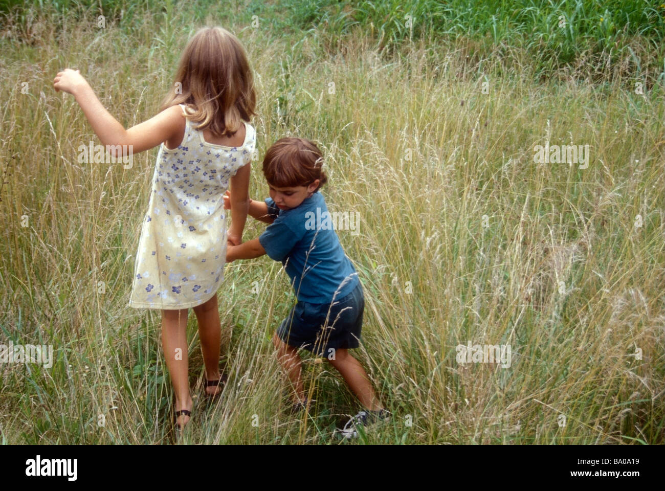 Kinder zu Fuß in Feld Gras Stockfoto