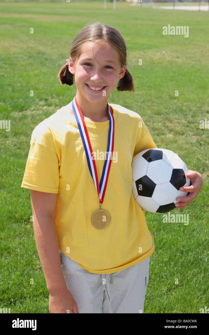 Mädchen mit Award-Medaille und Soccer ball Stockfoto