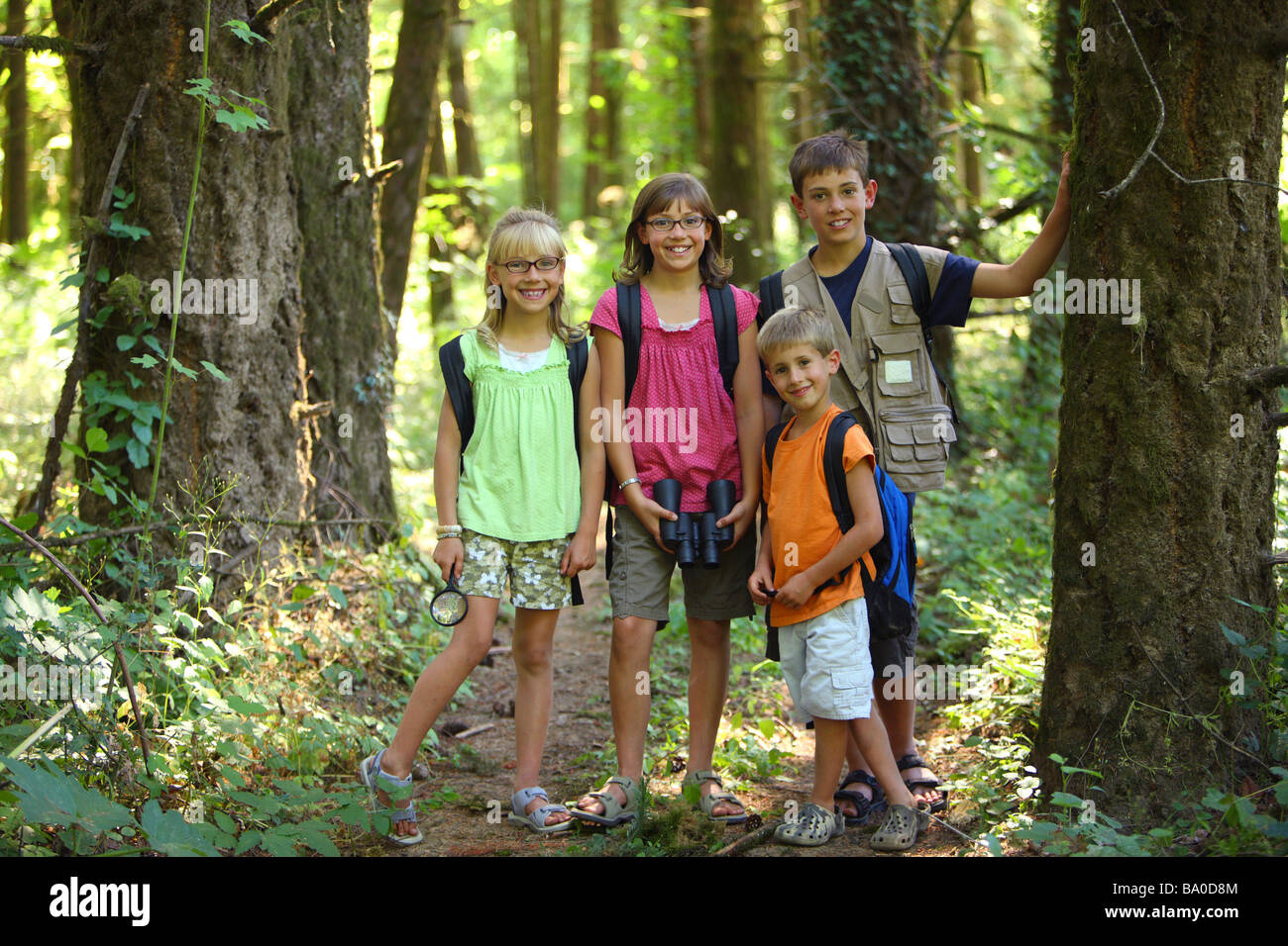 Gruppe von Kindern mit Campingausrüstung in Wäldern Stockfoto