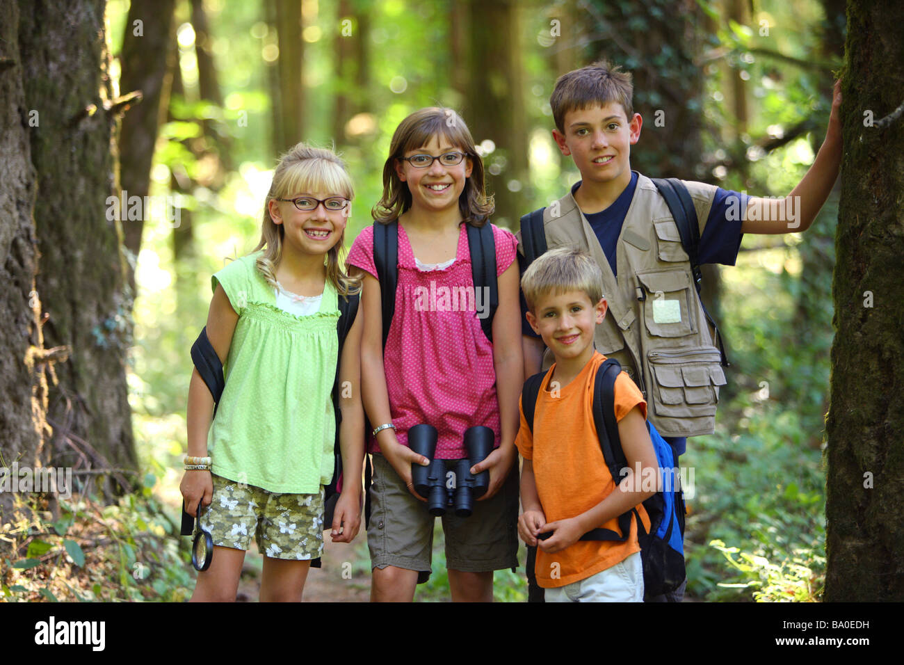 Gruppe von Kindern mit Campingausrüstung in Wäldern Stockfoto