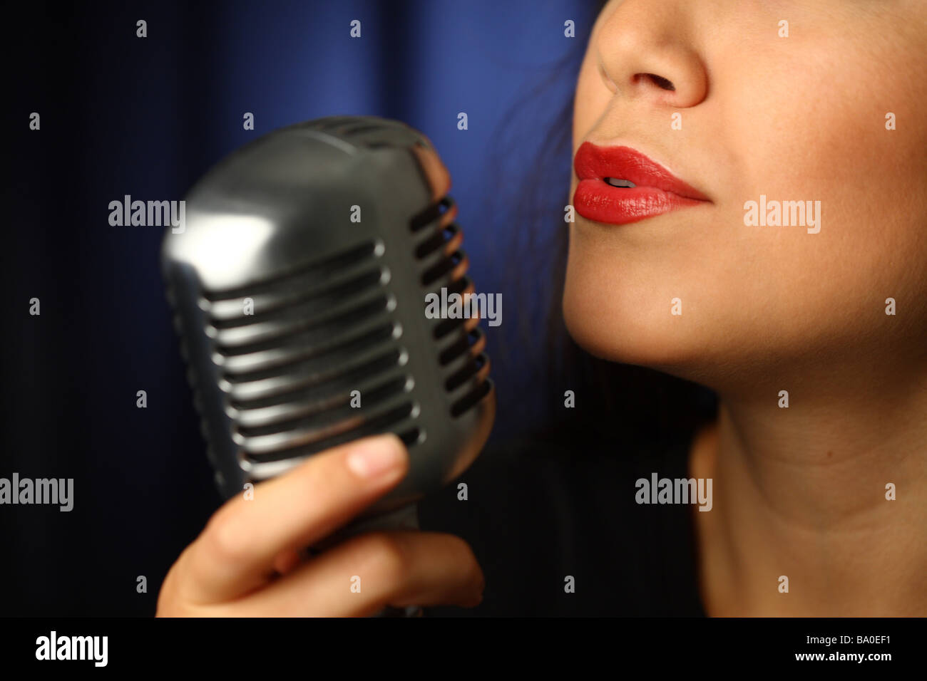 Nahaufnahme von Frau singt in Vintage Mikrofon Stockfoto