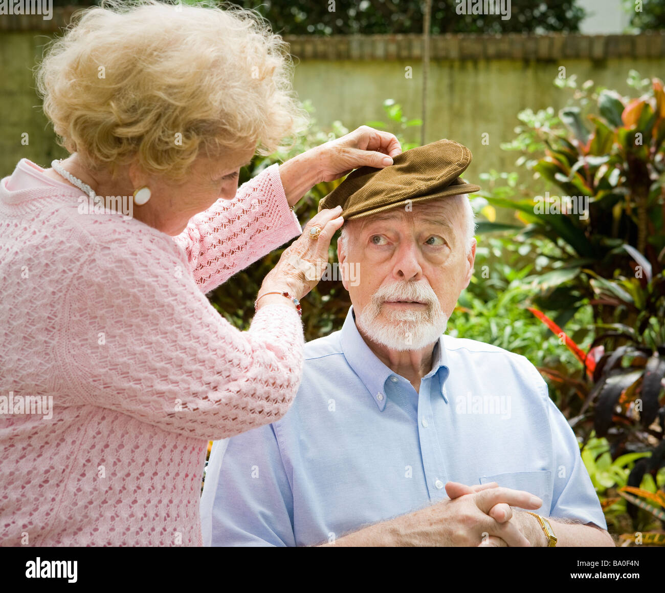 Liebevolle Frau kümmert sich um ihren älteren Ehemann mit Alzheimer-Krankheit Stockfoto