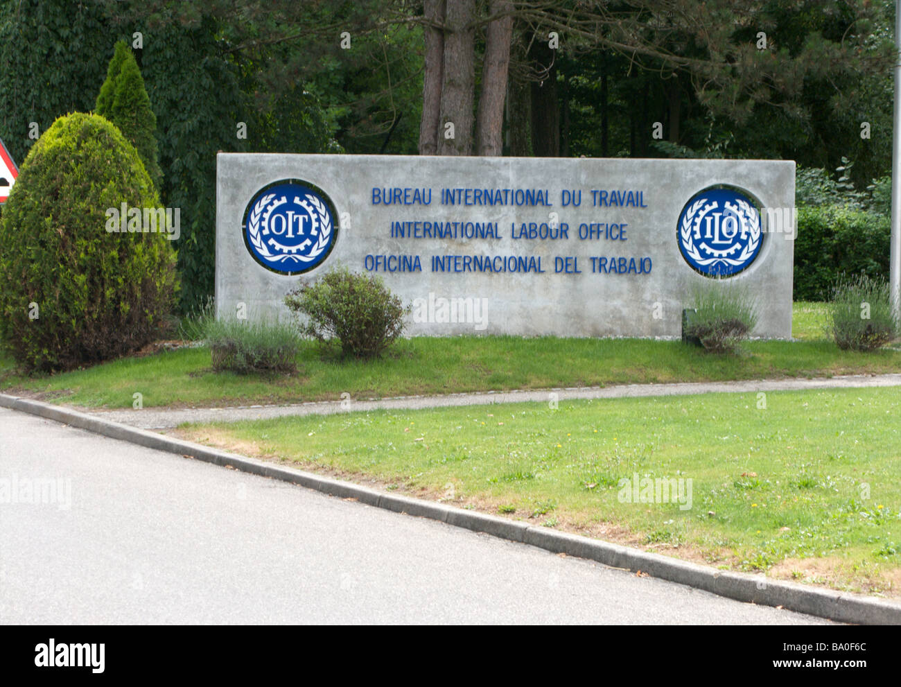 Einen Stein zu unterzeichnen, mit dem blauen schreiben in drei Sprachen zeigt den Eingang zu der International Labour Office, Genf, Schweiz Stockfoto