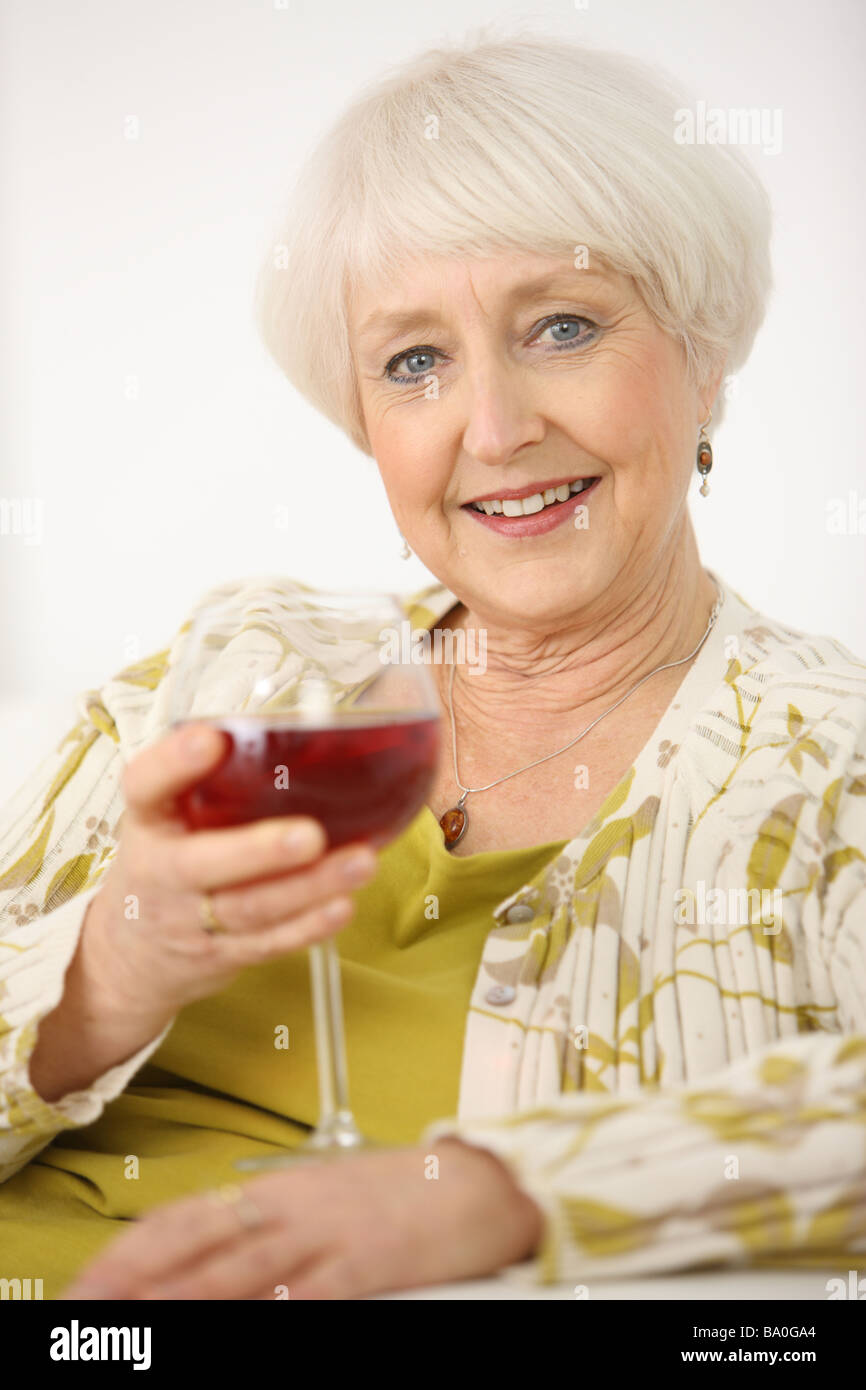 Ältere Frau mit Glas Wein Stockfoto
