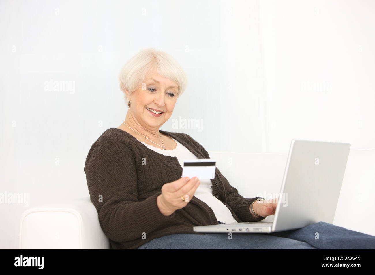 Ältere Frau mit Laptop-Computer und Kreditkarte Stockfoto