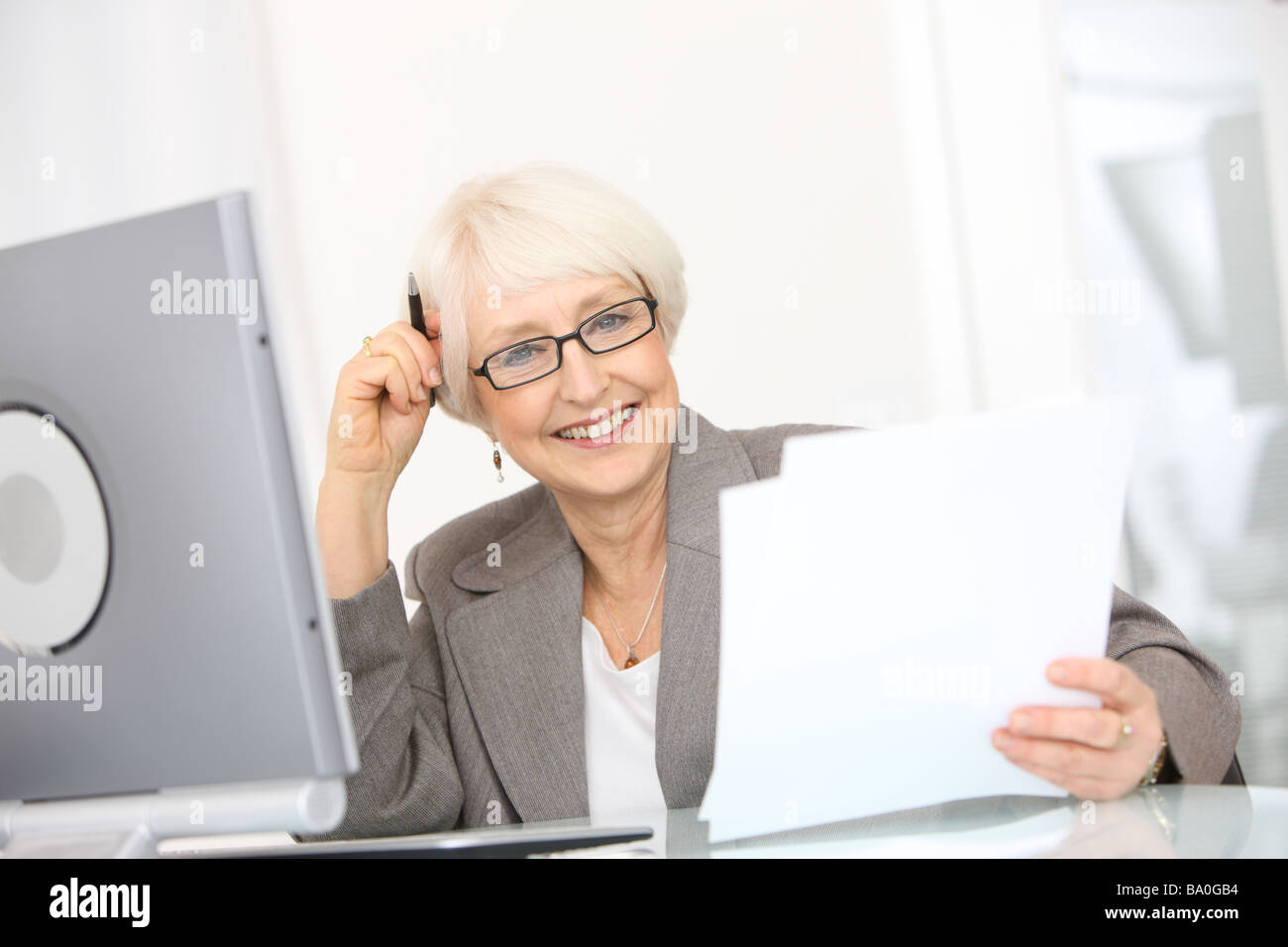Professionelle senior Geschäftsfrau mit Papieren Stockfoto