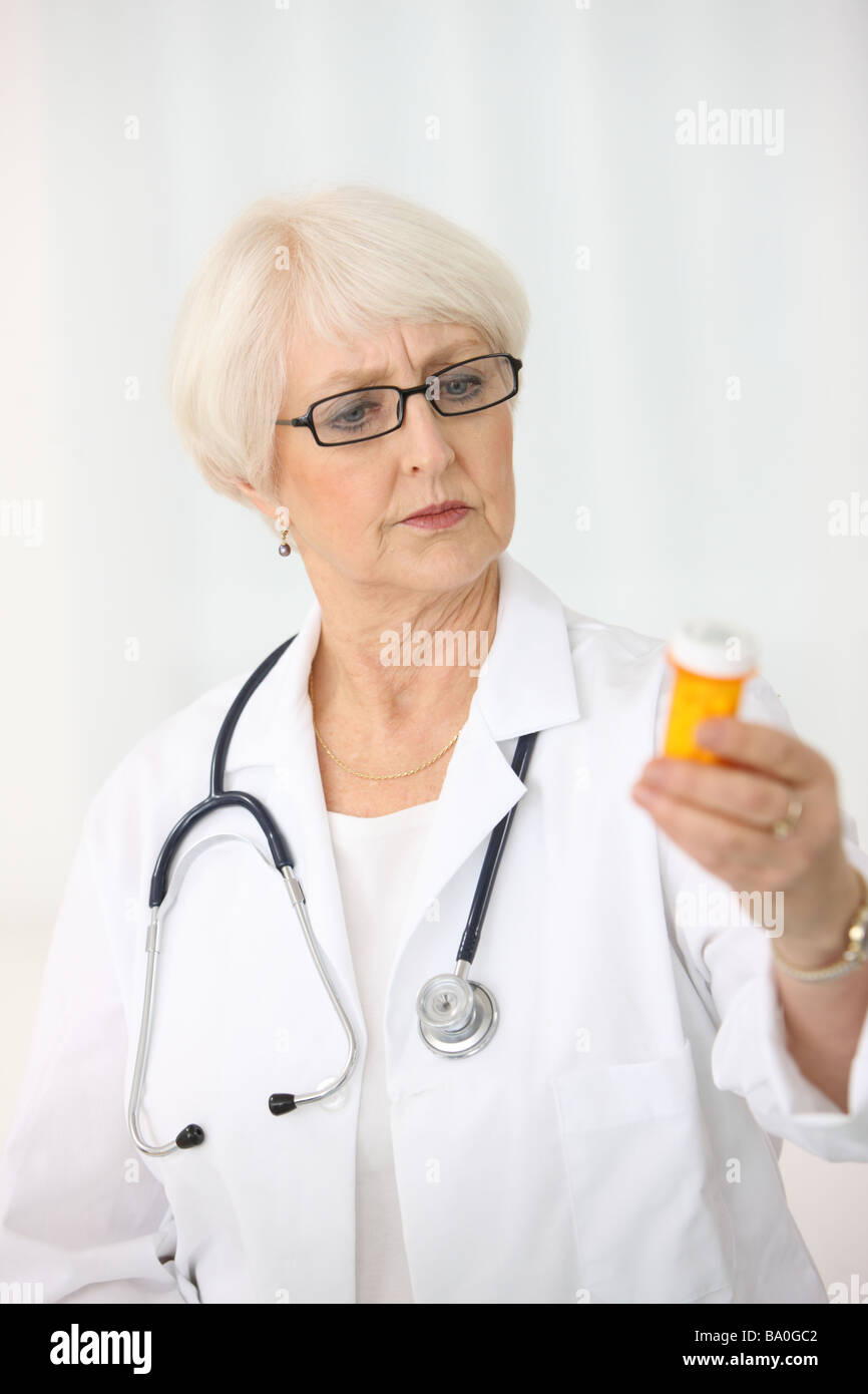 Leitende Ärztin Blick auf Pille Flasche Stockfoto