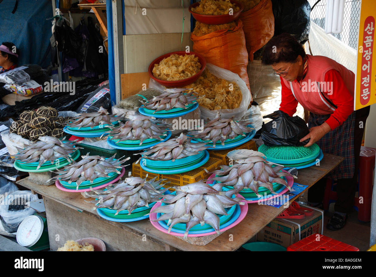 Eine alte koreanische Frau Verkauf von gebratenen Fischen im alten Fisch Markt Teil der Stadt Busan Stockfoto