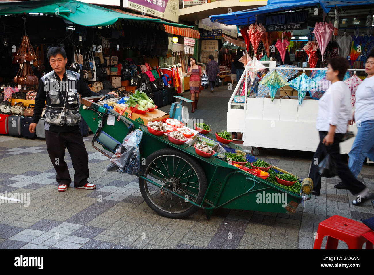 Ein Kaufmann seine frische Produkte für den Verkauf auf einen großen Wagen in der Mitte der Straße Marktplatz in der Stadt Busan anzeigen Stockfoto