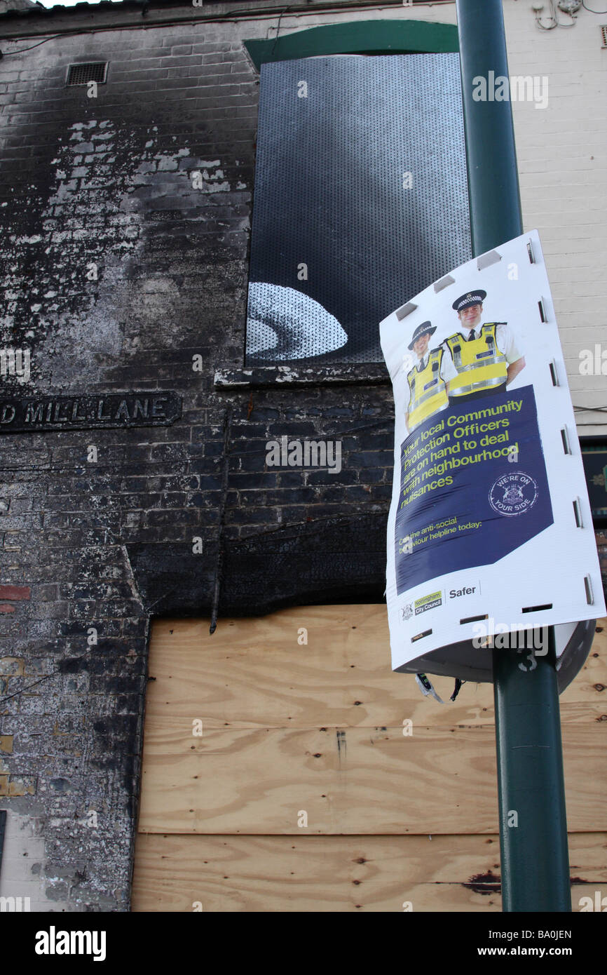 Eine Polizei anti-soziales Verhalten Schild draußen ein Feuer beschädigte Gebäude in einer Stadt, U.K. Stockfoto