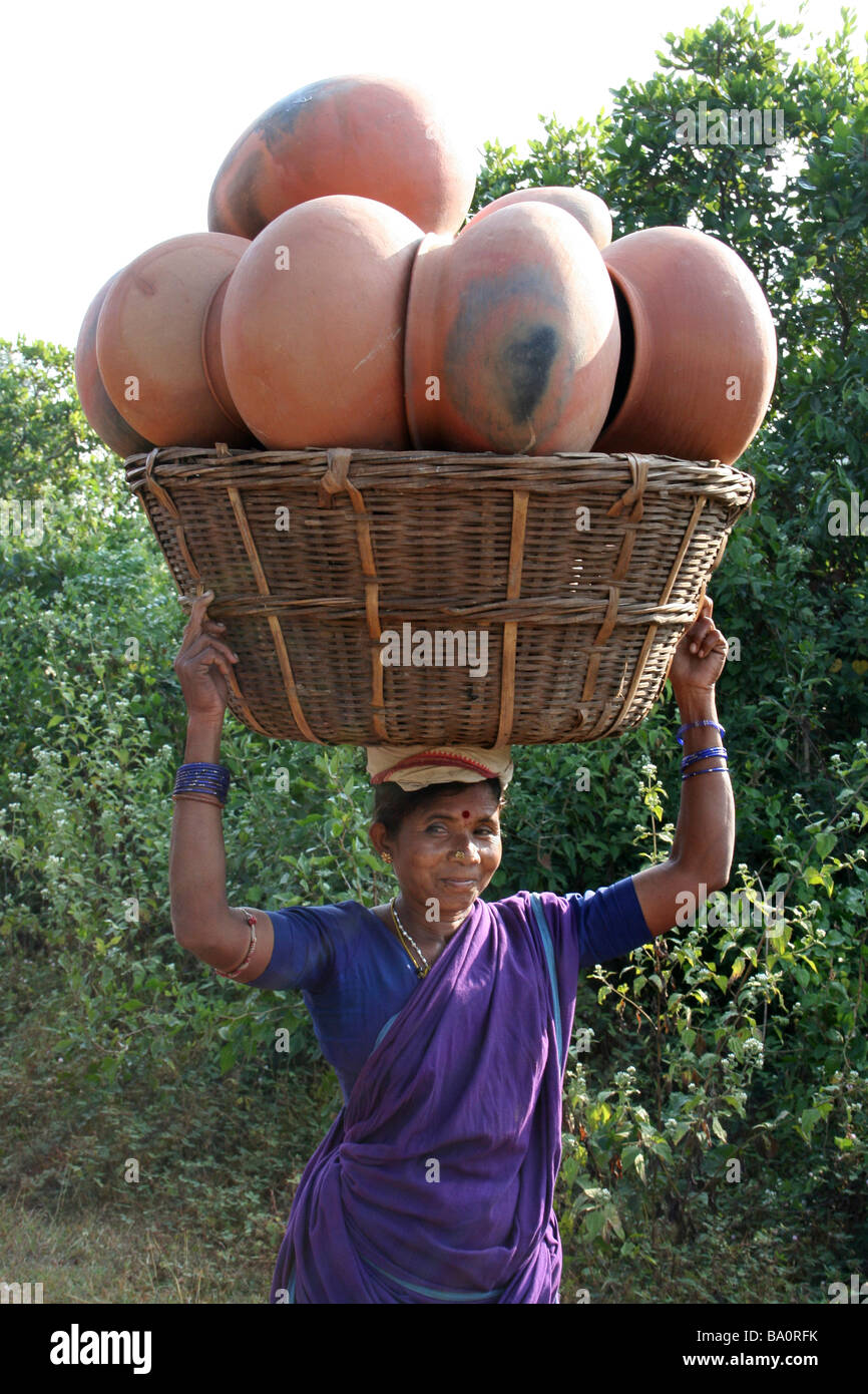 Indische Frau mit großen Korb voller Ton Kochtöpfe auf dem Kopf, Orissa Zustand Stockfoto