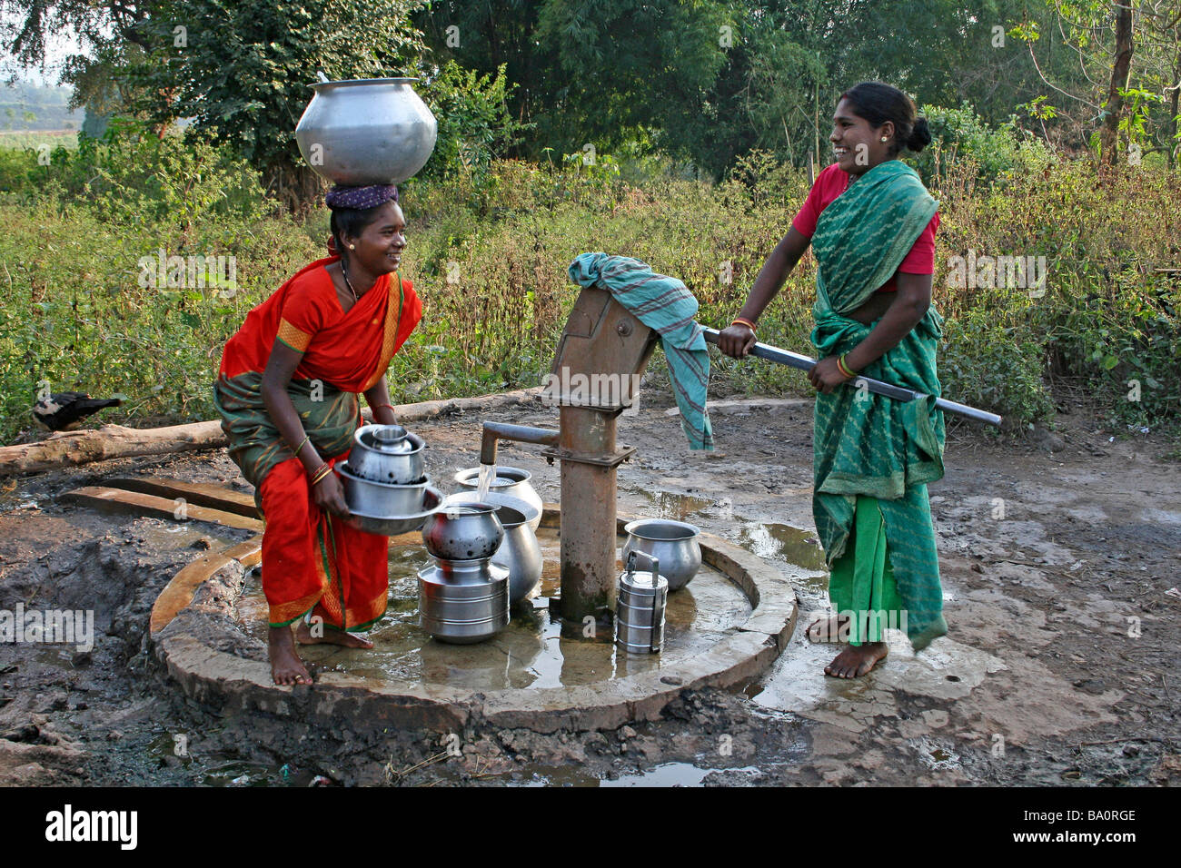 Zwei indische Frauen des Stammes Paroja Lachen und Lächeln, während Wasser gut aus dem Dorf zu sammeln Stockfoto