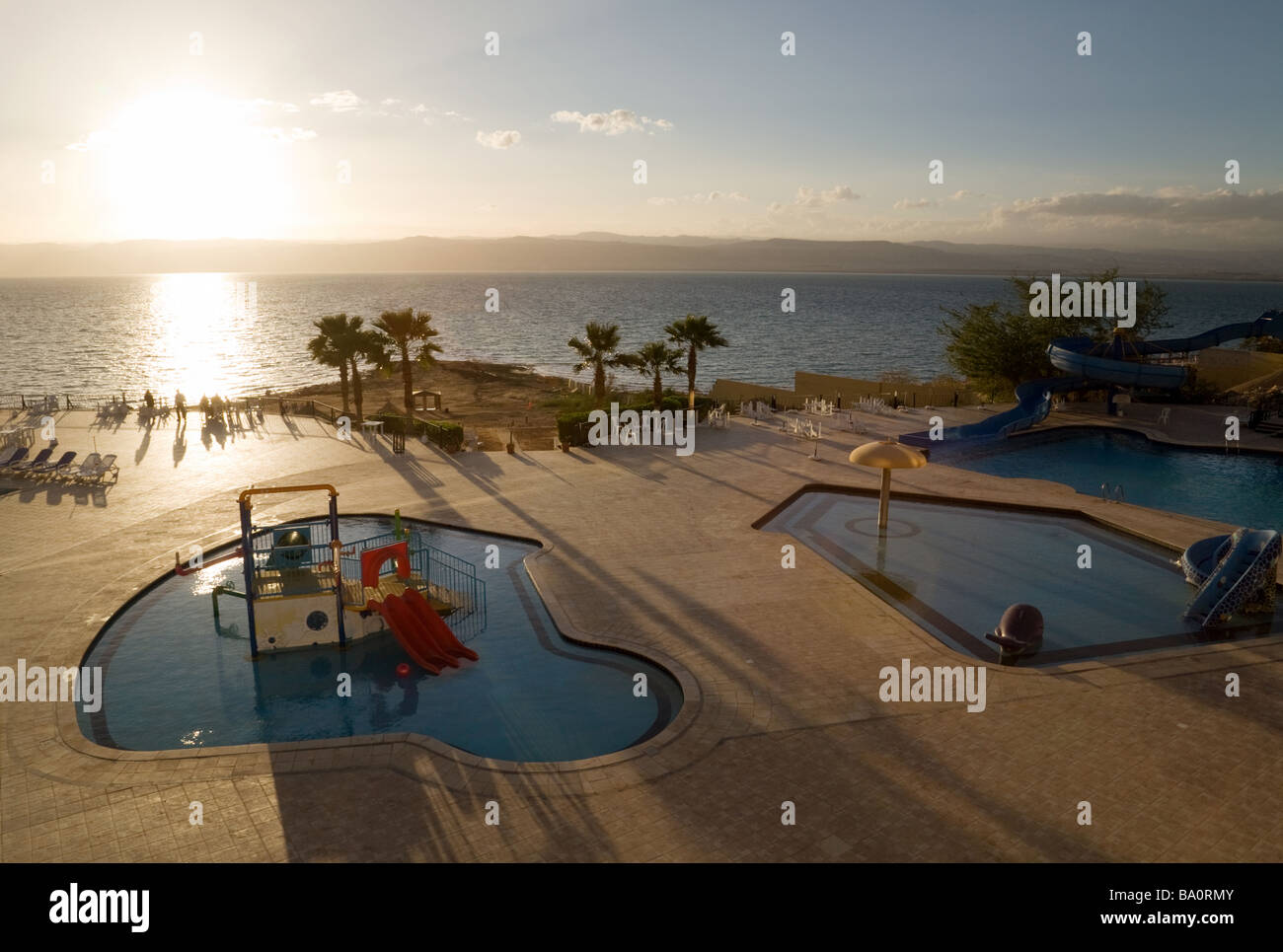 Blick von der Dead Sea Spa Beach Hotel über die Pools und Totes Meer bei Sonnenuntergang, Jordanien Stockfoto