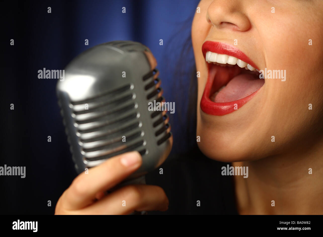 Nahaufnahme von Frau singt in Vintage Mikrofon Stockfoto