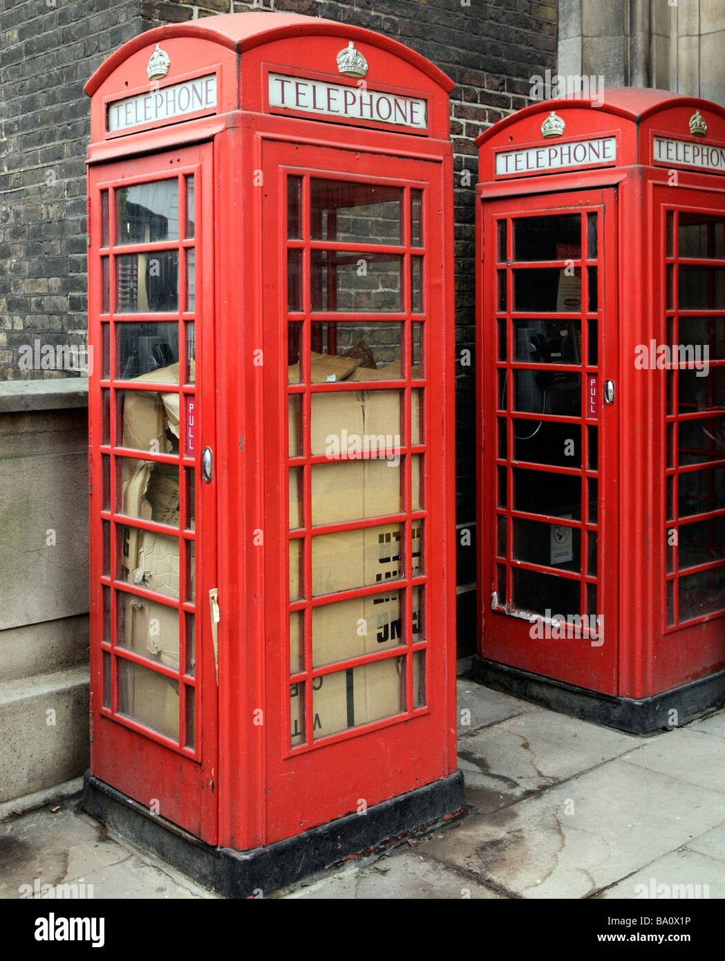 Ein Landstreicher unter Kartons, schlafen rau in eine öffentliche Telefonzelle. London, England, Vereinigtes Königreich. Stockfoto