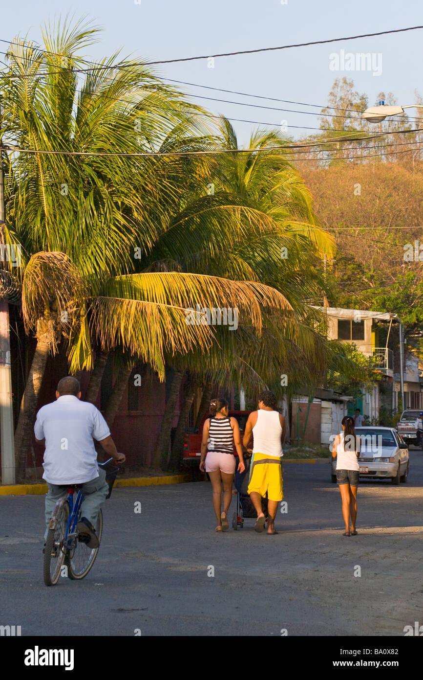 Straßenszene San Juan del Sur mit Familie zu Fuß die Straße runter bei Sonnenuntergang in Nicaragua. Stockfoto
