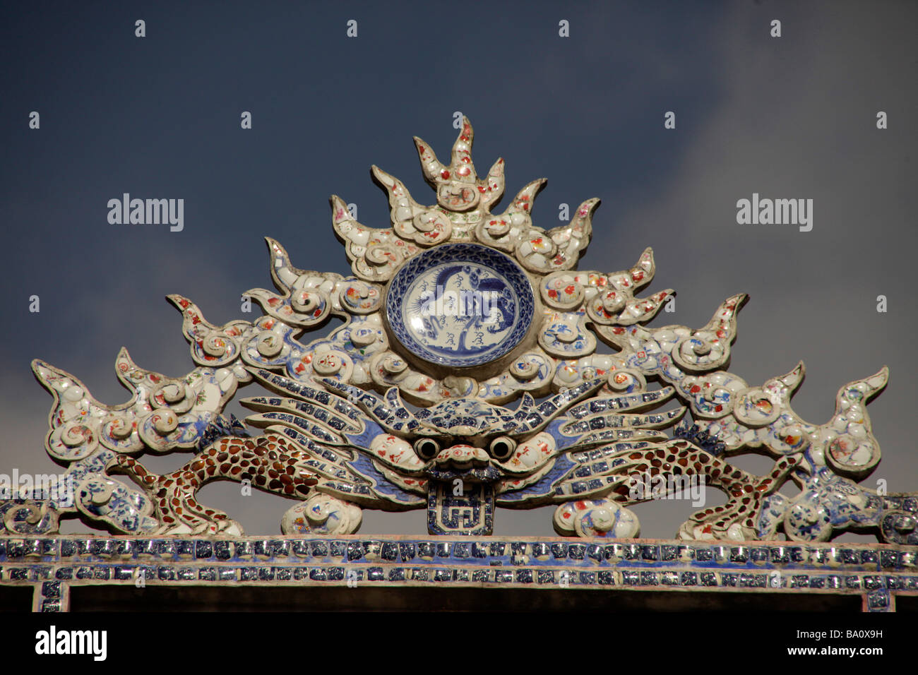 Drachen und Porzellan auf einen chinesischen Tempel Dach in Hoi An Vietnam Stockfoto