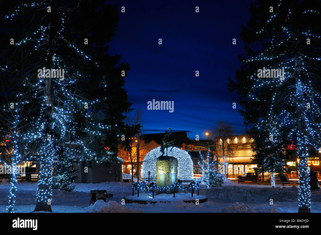 Weihnachtsbeleuchtung Elch Geweih Bögen und Bäume in Jackson Wyoming USA Altstädter Ring im Winter in der Dämmerung mit Cowboy auf bucking Broncho-statue Stockfoto
