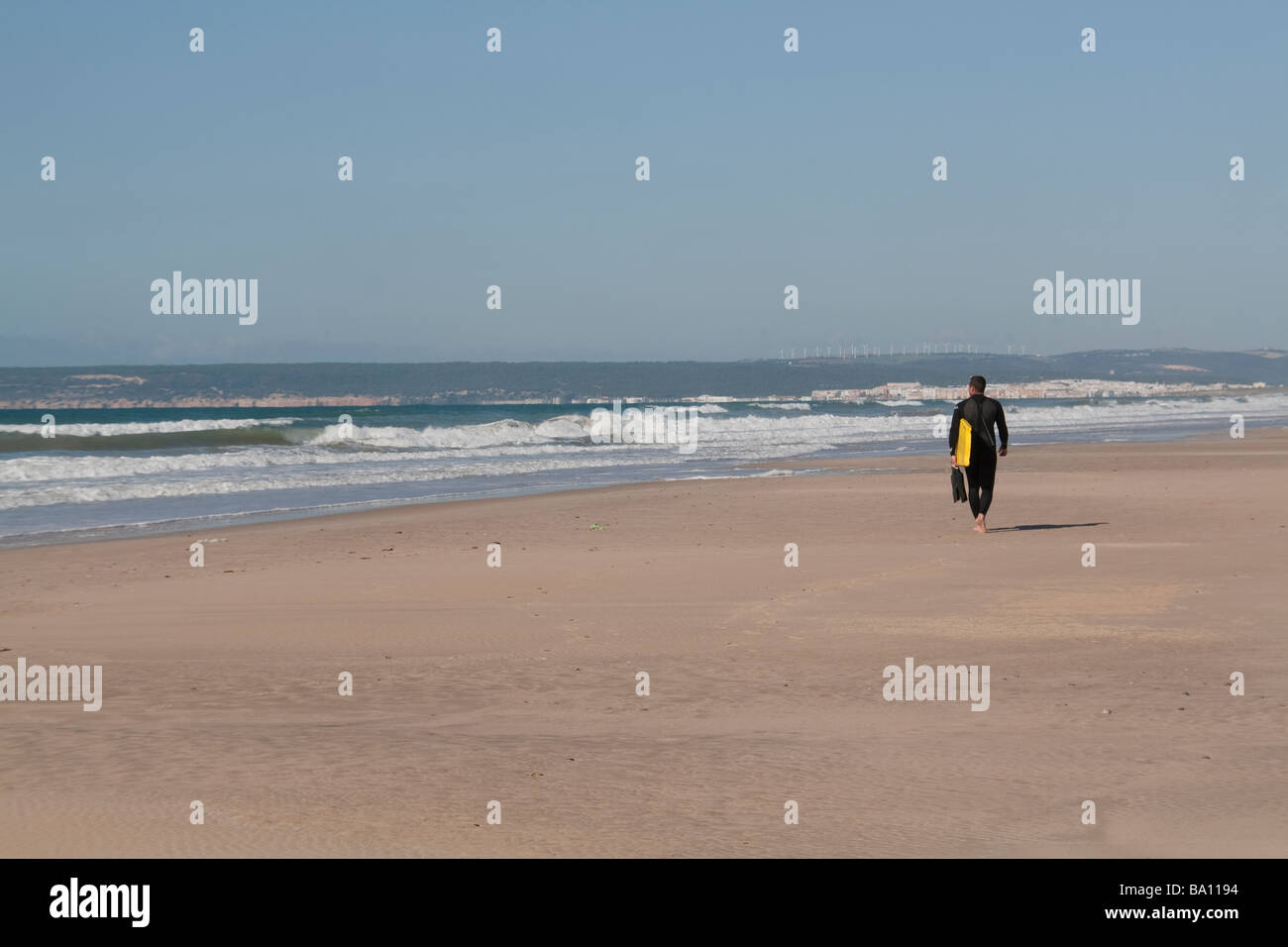 Surfer-Mann zu Fuß am Strand Stockfoto