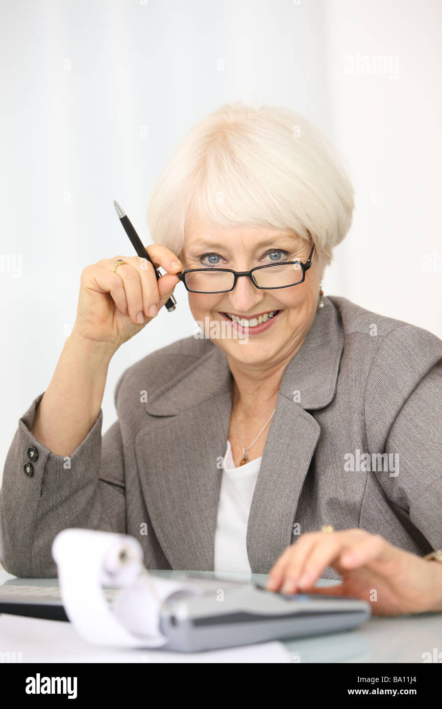 Professionelle senior Geschäftsfrau mit Taschenrechner Stockfoto