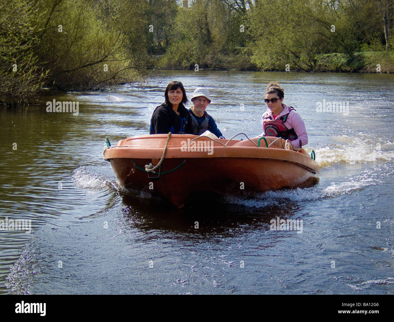 Drei Personen in einem rationalen geformten Boot auf dem Fluss Ouse in York, North Yorkshire. VEREINIGTES KÖNIGREICH Stockfoto