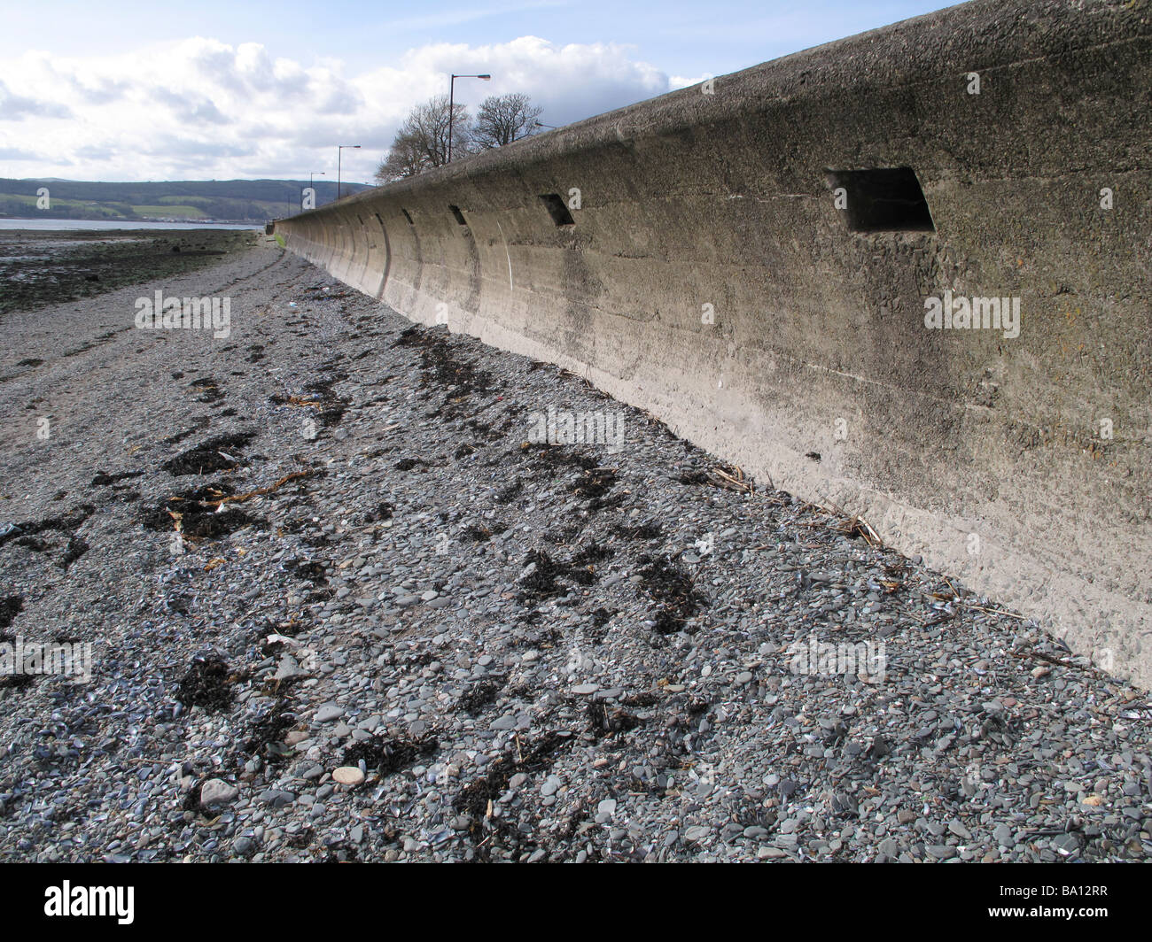 Ufermauer stoney Strand entlang Stockfoto