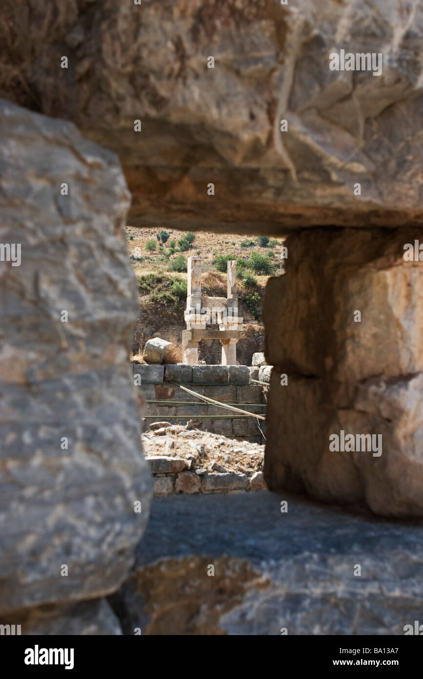 Zeigen Sie auf Domitian Tempel Ruinen in Ephesus durch Loch in Steinmauer, Türkei an. Stockfoto