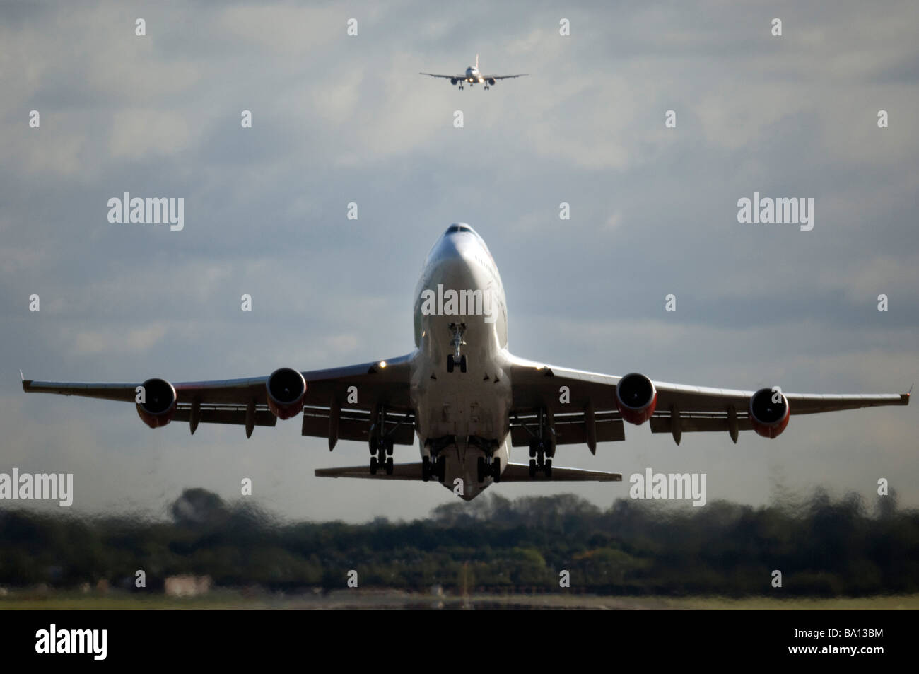 Virgin Atlantic Boeing 747 Jet-Flugzeug startet vom Gatwick Flughafen West Sussex mit einem kleineren Jet kommen ins Land hinter Stockfoto