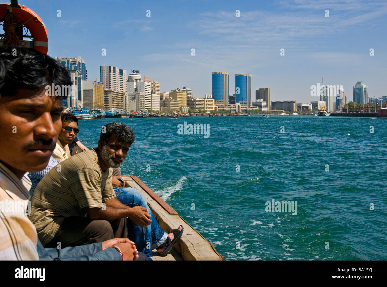 Ausländische Arbeitnehmer auf einer kleinen Dhau, die Menschen als ein Taxi zu benutzen, von Bur Dubai, Deira zu Stockfoto