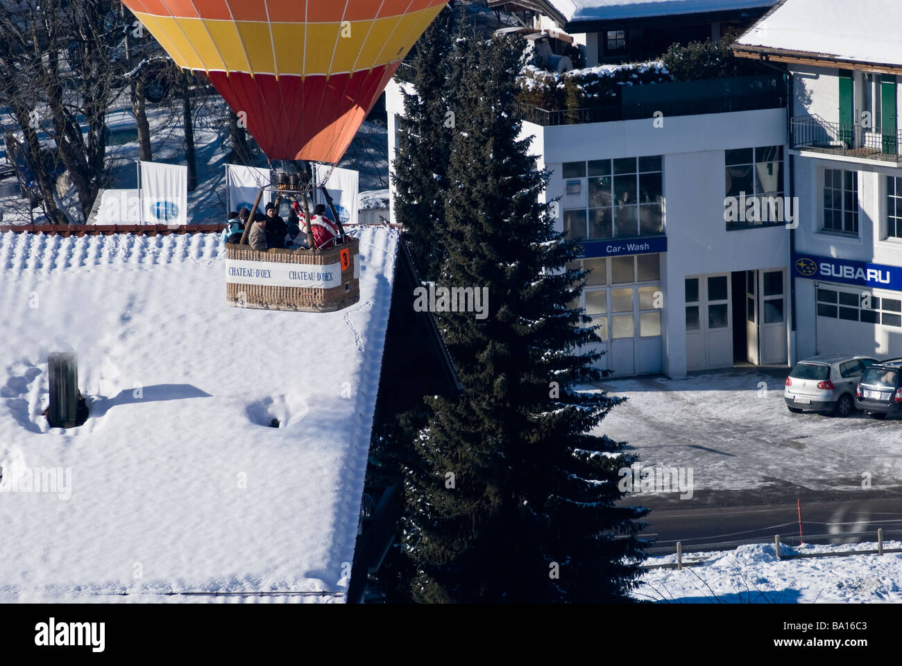 Ein Ballon Röcke über Dächer auf der 2009 International Hot Air Balloon Festival Chateau d ' Oex Schweiz. Charles Lupica Stockfoto