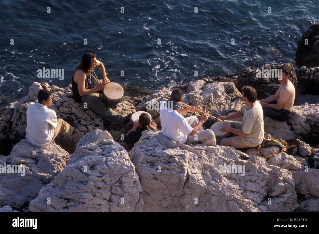 Musiker Jamming auf Felsen neben Mittelmeer Nizza Frankreich Stockfoto