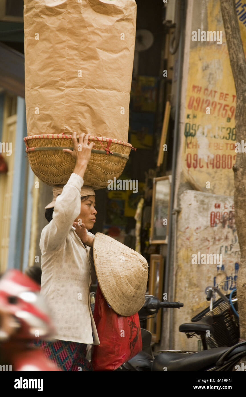 Verkäufer eine Last auf dem Kopf in Hanoi auf Ausgleich Stockfoto