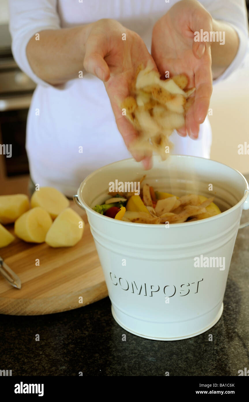 Frau weglegen Kartoffelschalen in Kompost Stockfoto