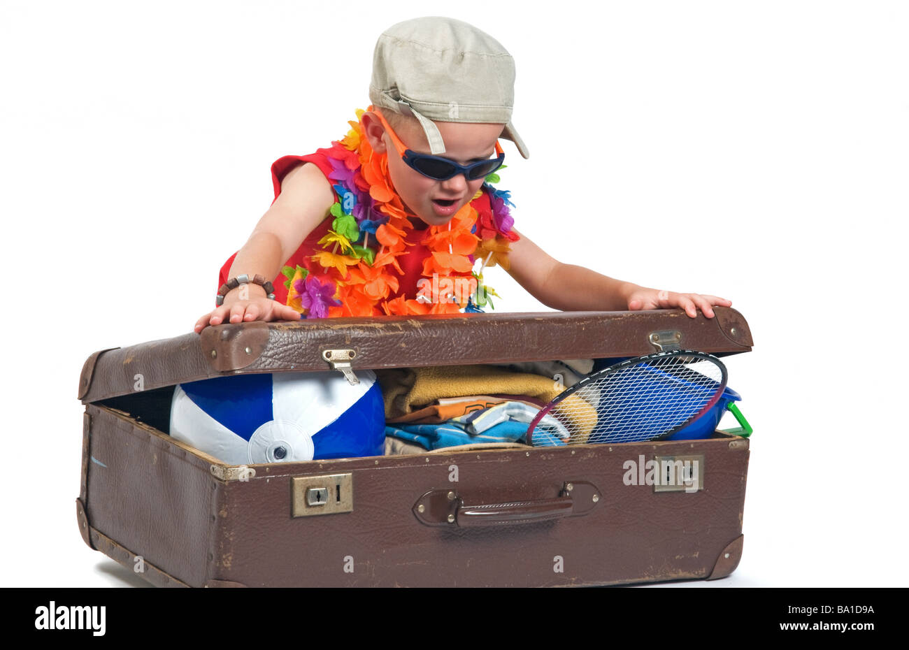 Kleiner Junge versucht, alle seine Sachen für den Sommerurlaub in seinem Koffer passen Stockfoto