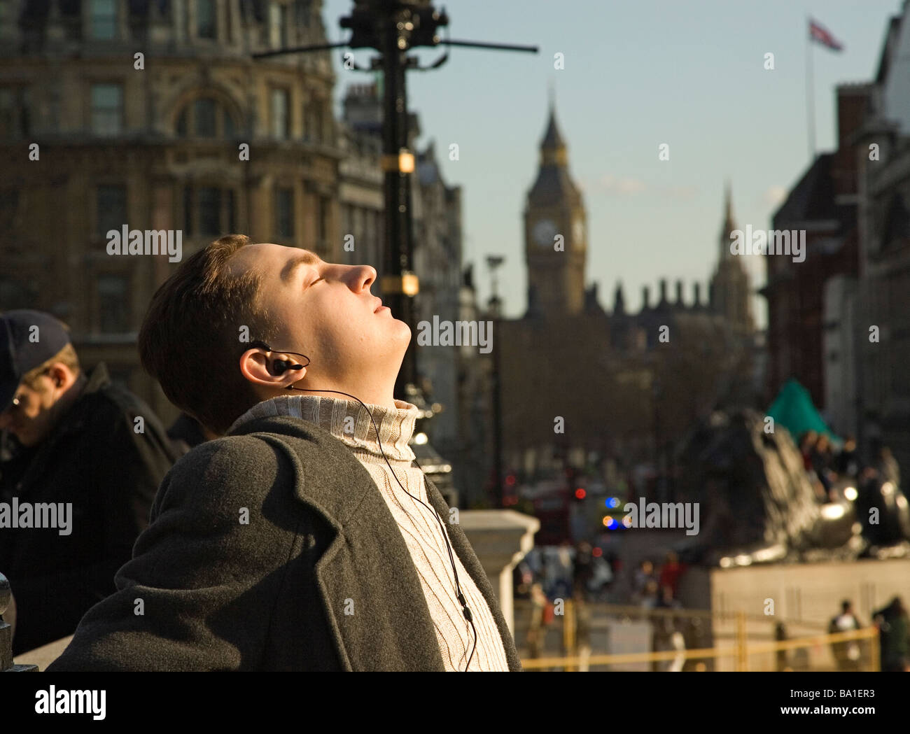 Ein Mann genießt die Frühlingssonne am Trafalgar Square in London Stockfoto