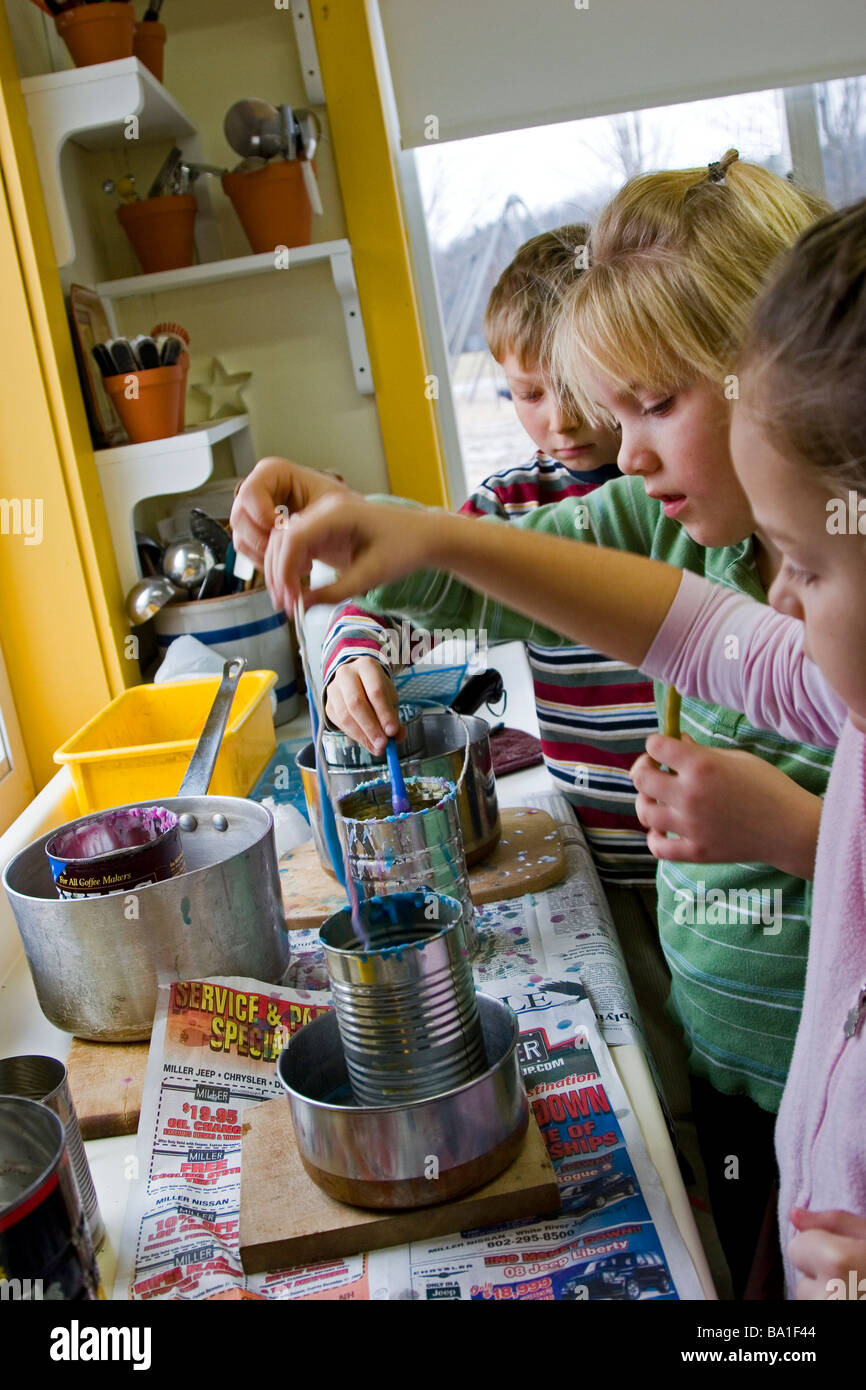 Drei Kinder machen Kerzen mit Wachs in der Schule Stockfoto